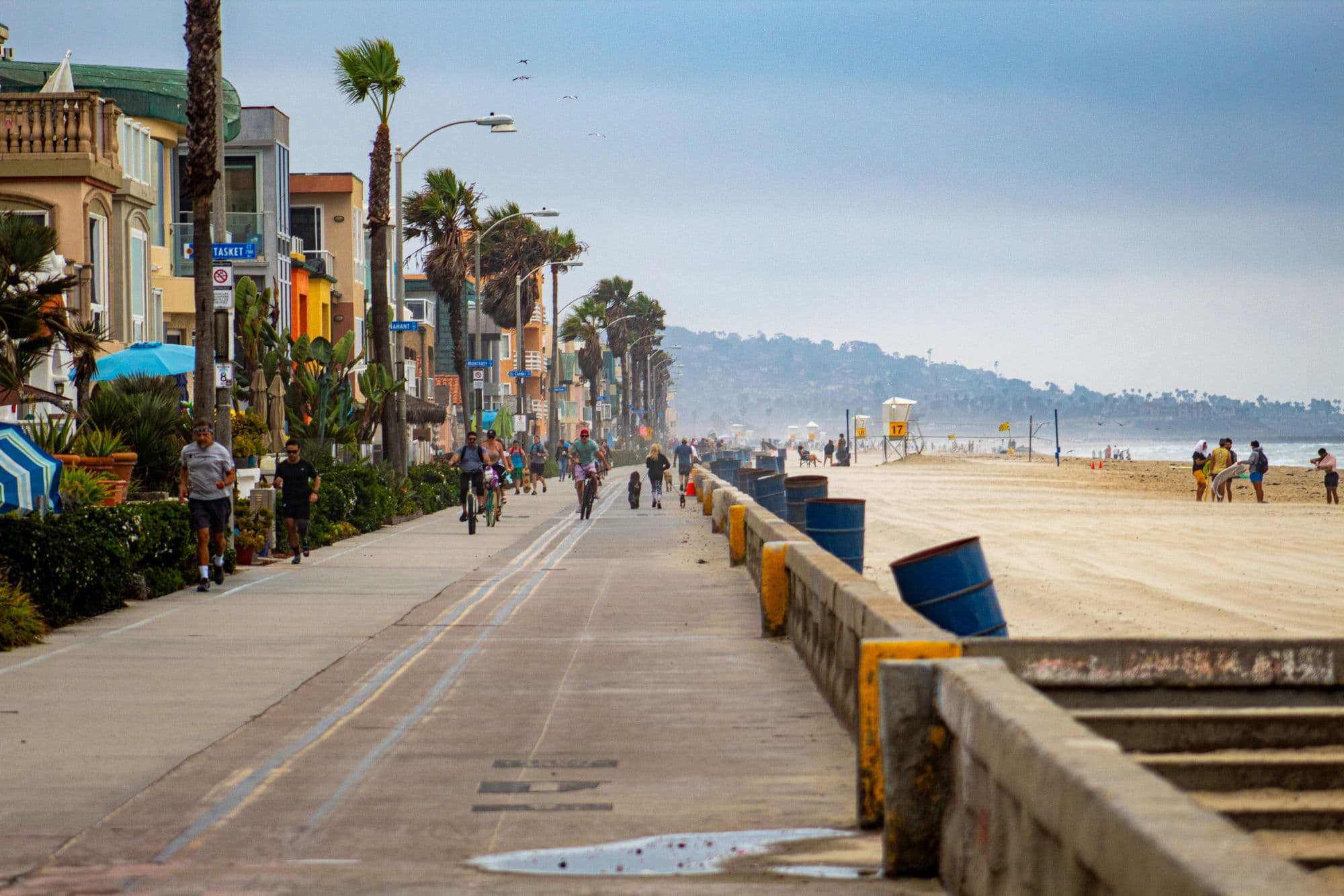 The Pacific Beach boardwalk lined with palm trees and beach cottages